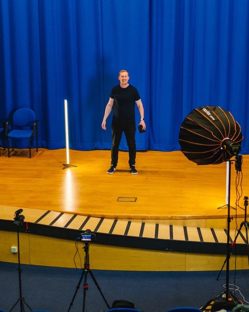 Sam on a stage, setting up for a shoot
