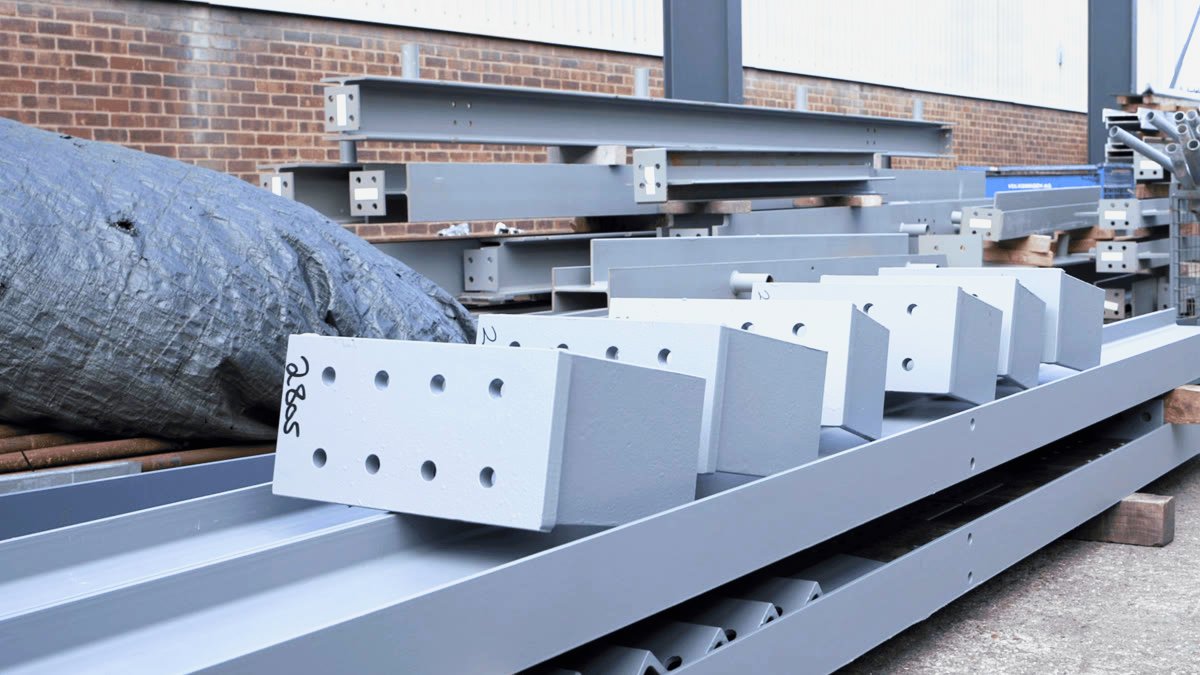 Primer coated steel beams and column sections with drilled connection plates in the Apex yard