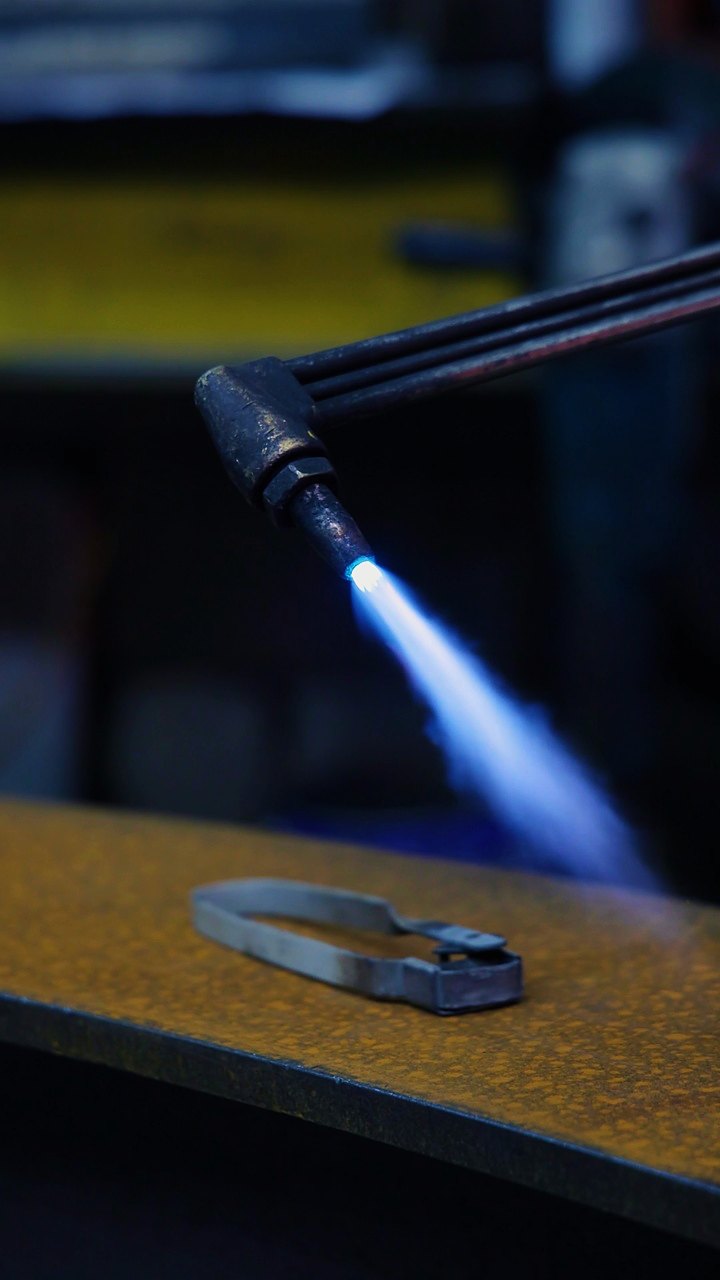 A blue gas flame from a cutting torch over a steel plate