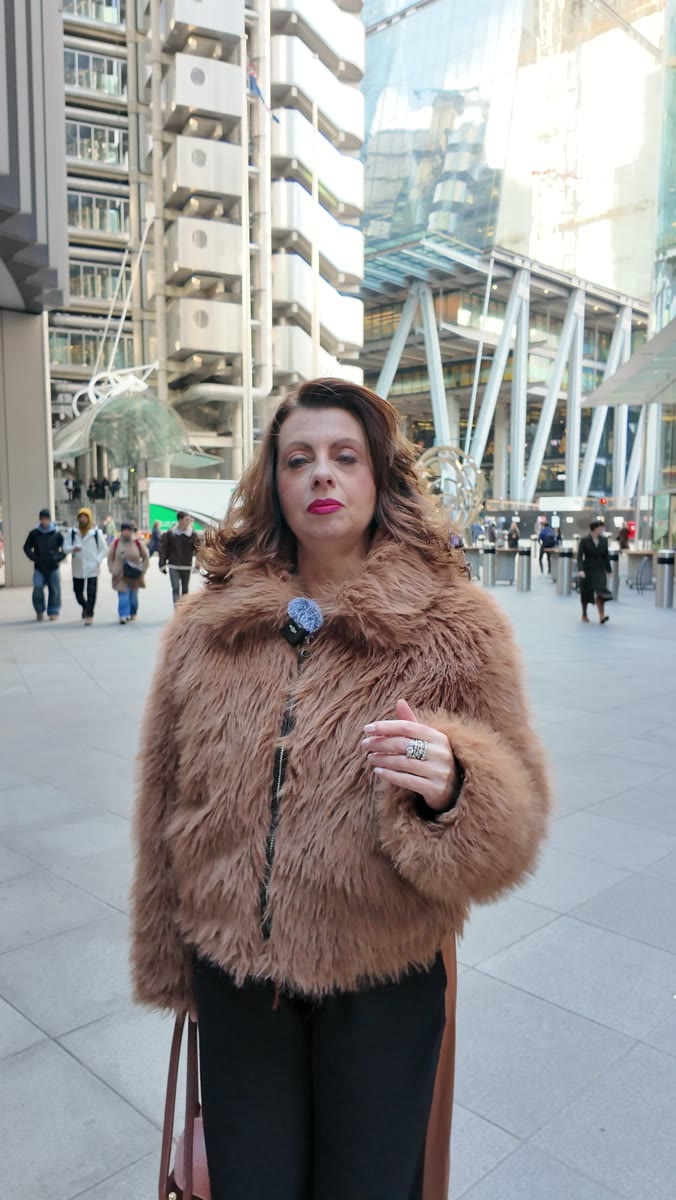 Liz Flavell delivering a piece to camera on a City of London street