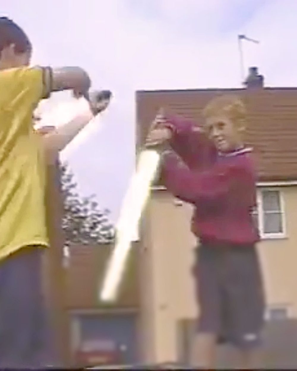 A still from one of Sam's childhood videos: 2 kids with homemade lightsaber props