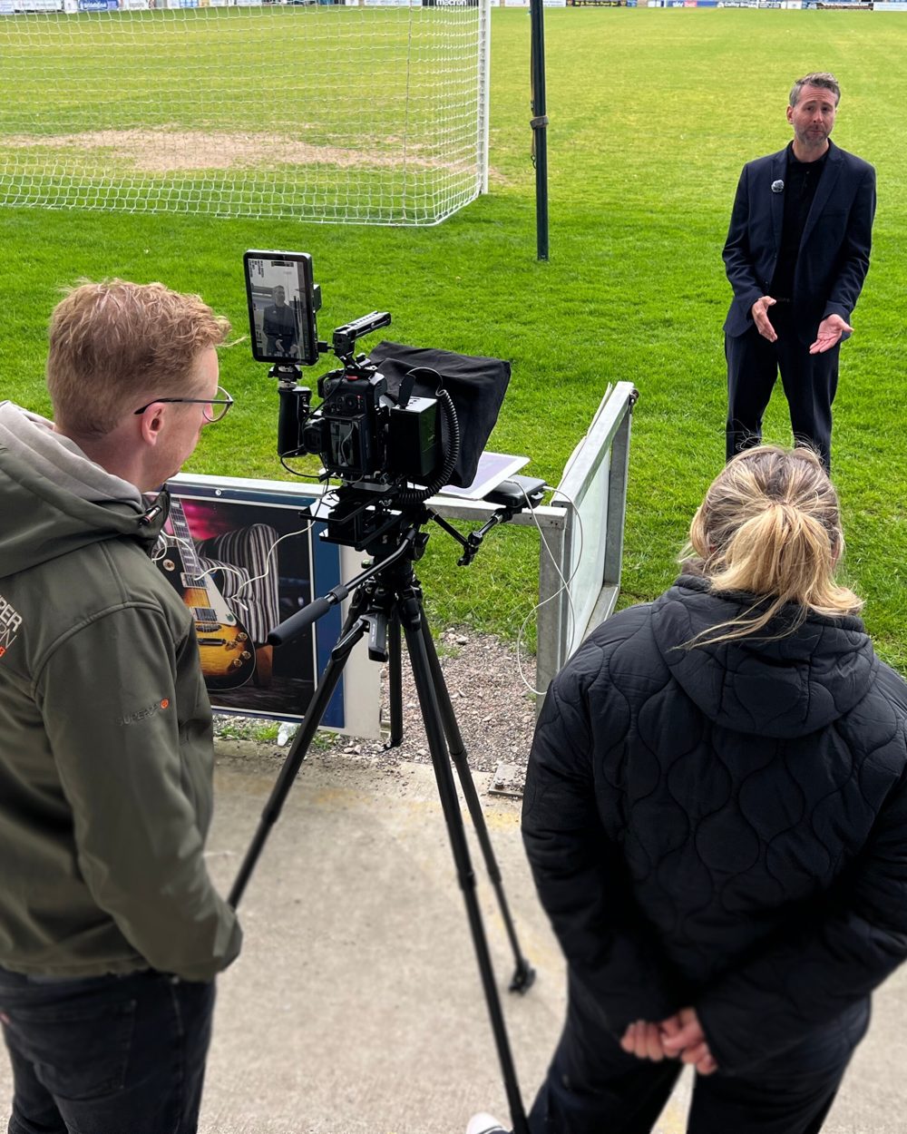 Sam directing a video shoot on a football pitch