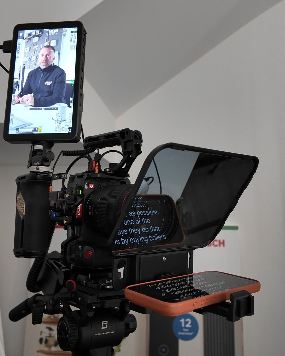 Camera, teleprompter and monitor on a tripod with the script scrolling