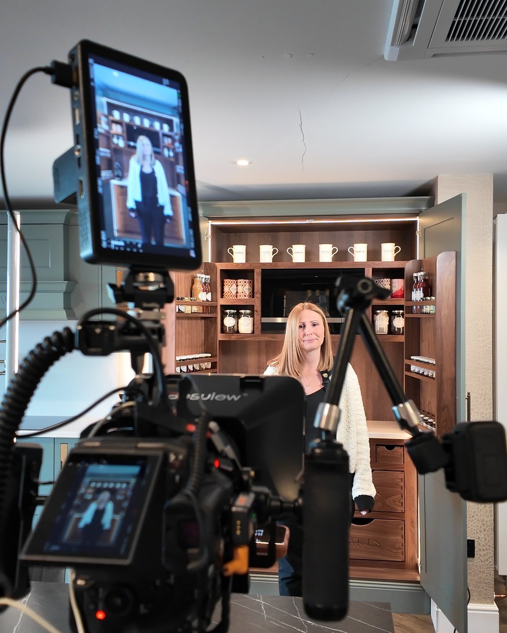 Our camera and monitor set up in a kitchen showroom, with a presenter at the units behind