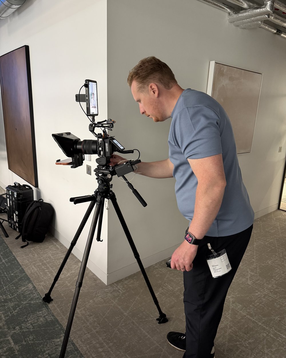 Sam setting up the camera rig on a tripod before an interview