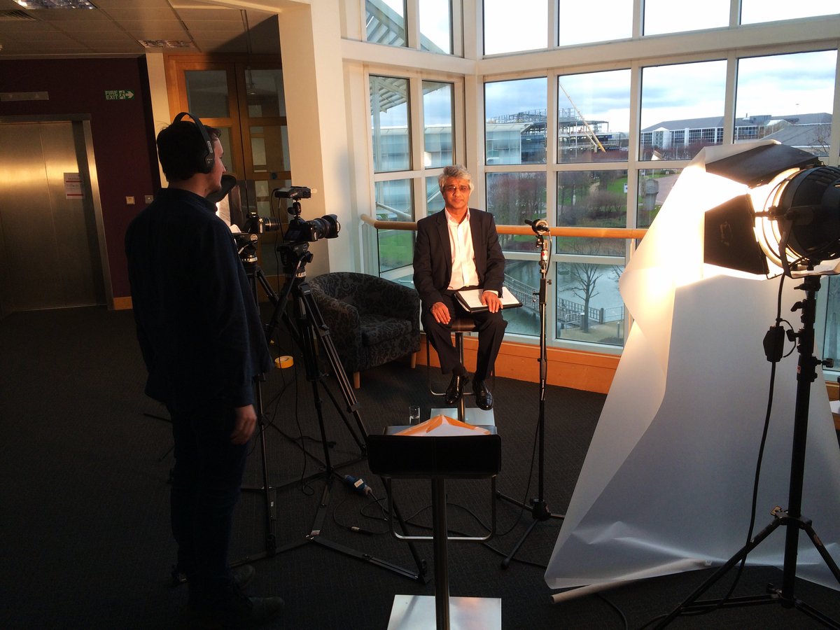 A corporate interview set up in an office with a softbox, camera and crew