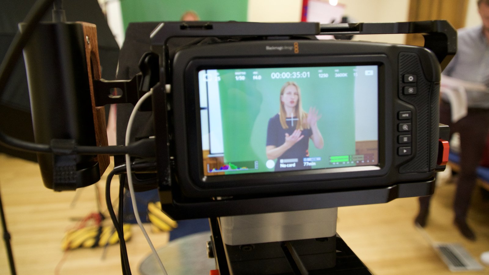 A camera monitor showing a framed interview with exposure and focus overlays, ready for review