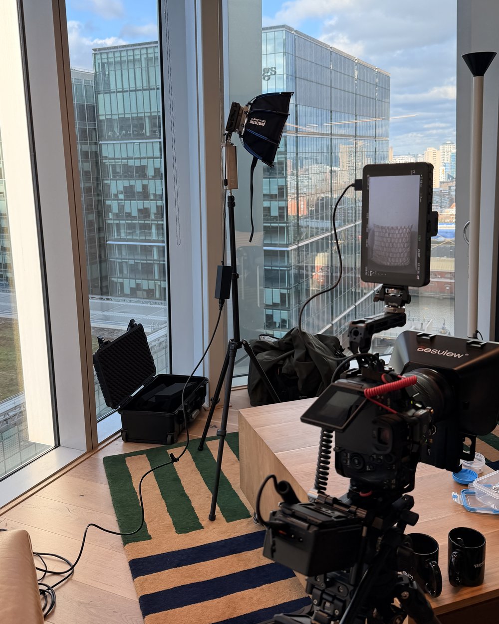 Interview rig with monitor, key light and kit case set up in a high-rise room for a coach's shoot day