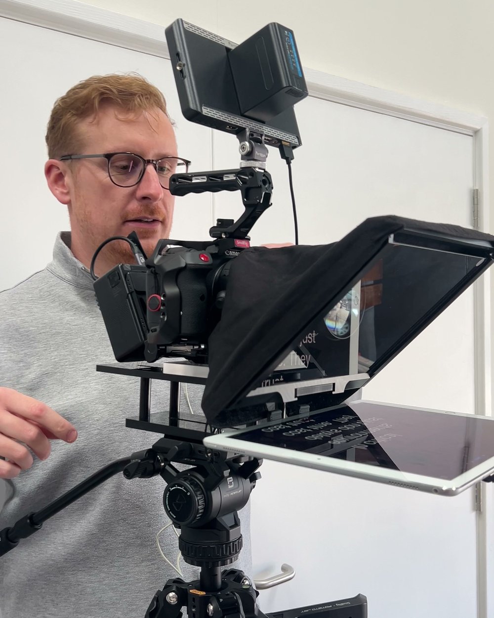 Sam checking a teleprompter and monitor on a camera rig before a take