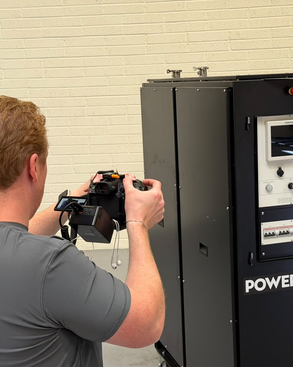 Sam filming a factory machine up close on a camera rig