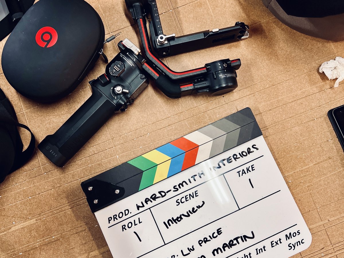 A clapperboard, gimbal and headphones laid out on a workshop bench
