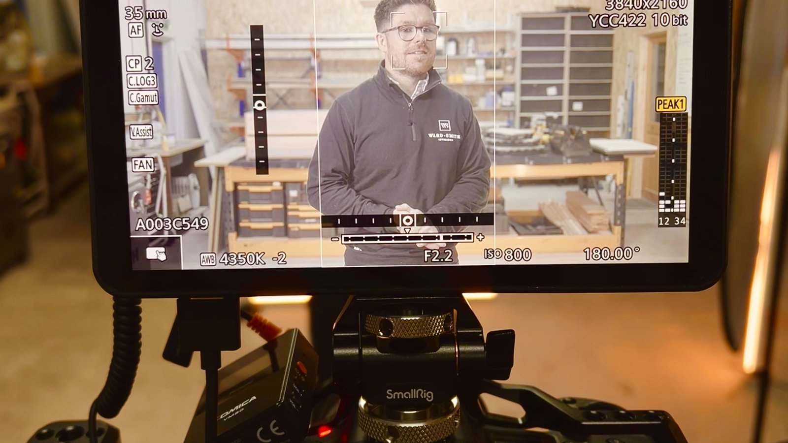 A camera monitor showing a framed interview with exposure and focus overlays, ready for review