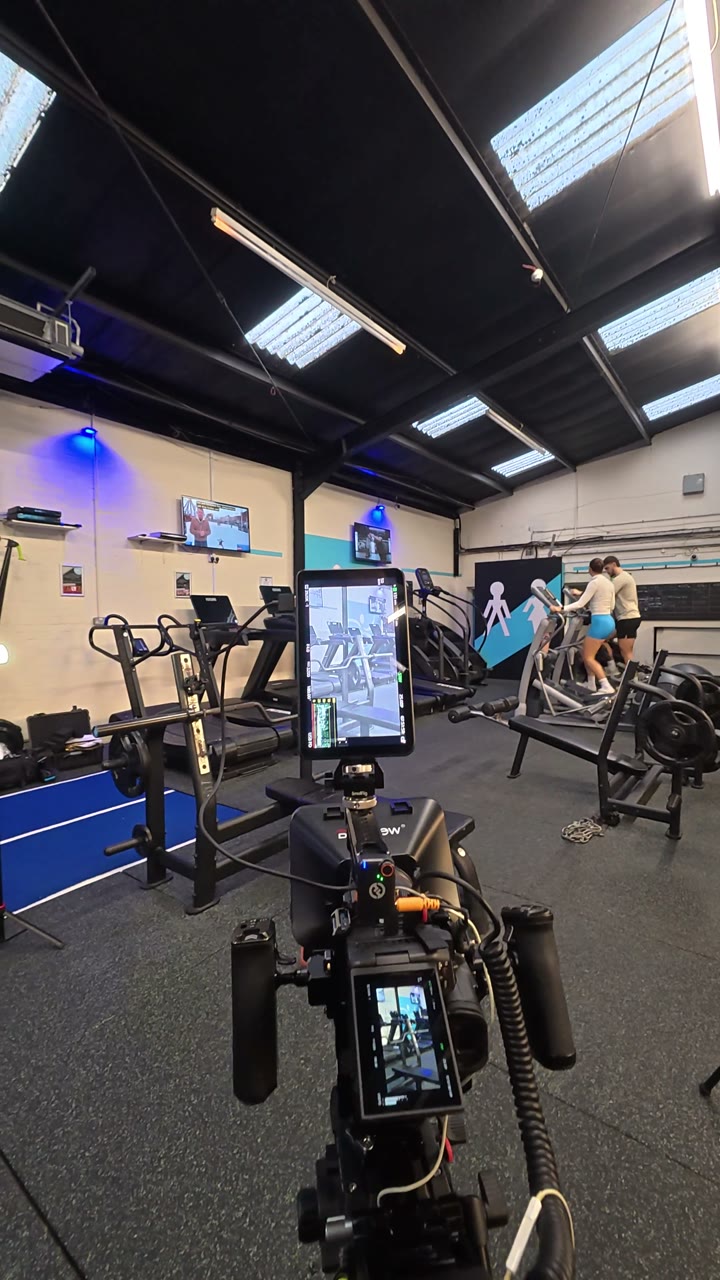Behind the scenes of a cinema camera set up on the gym floor