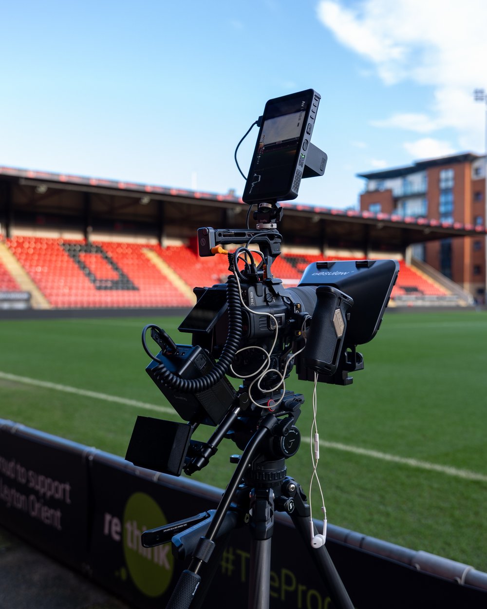 Camera, monitor and teleprompter on a tripod pitchside at a football stadium