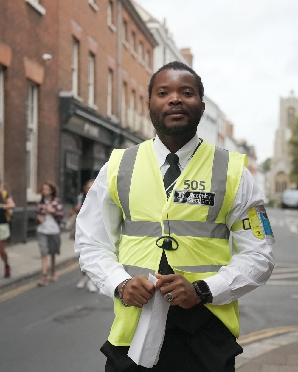 Regency Security officer in hi-vis smiling to camera on a Norwich street during Run Norwich