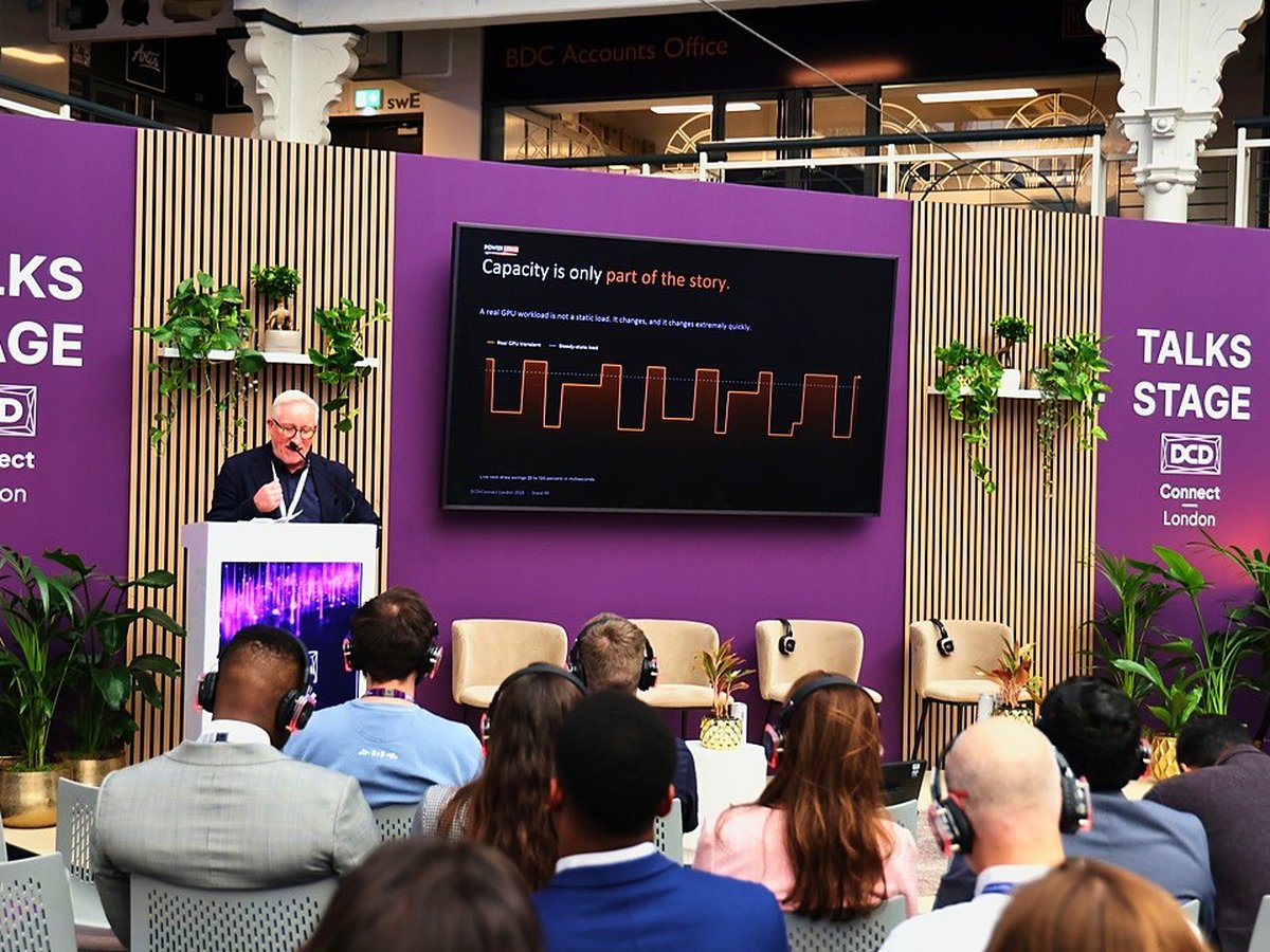 A speaker on the Talks Stage at DCD Connect London with an audience watching